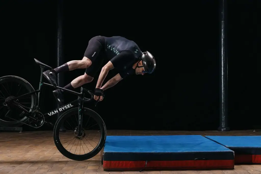 Cycliste portant le skinsuit Van Rysel Projet AIRBAG lors d'un test de chute simulée sur des matelas de protection