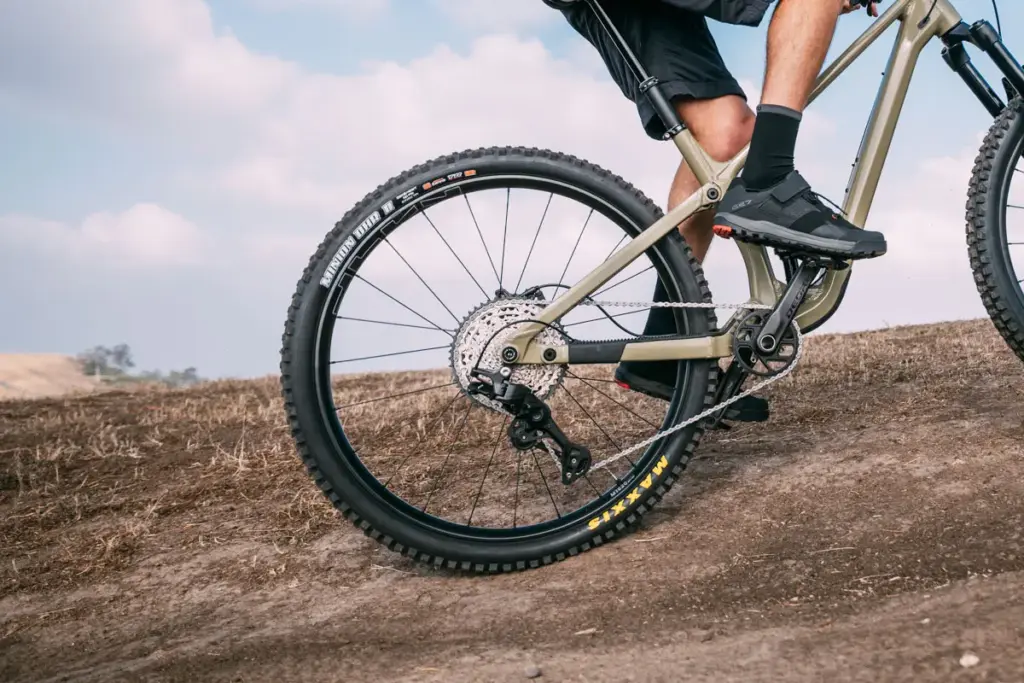 Rider climbing with a mechanical Shimano DEORE drivetrain