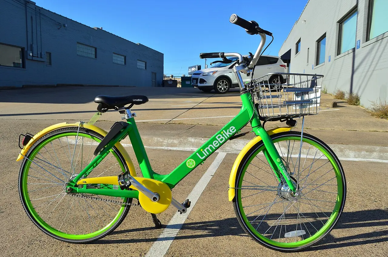 Vélo vert et jaune LimeBike garé sur un parking