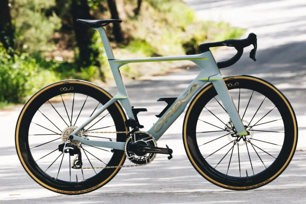 Orbea Orca Aero 2027 en extérieur, coloris gris avec liseré doré, roues OQUO
