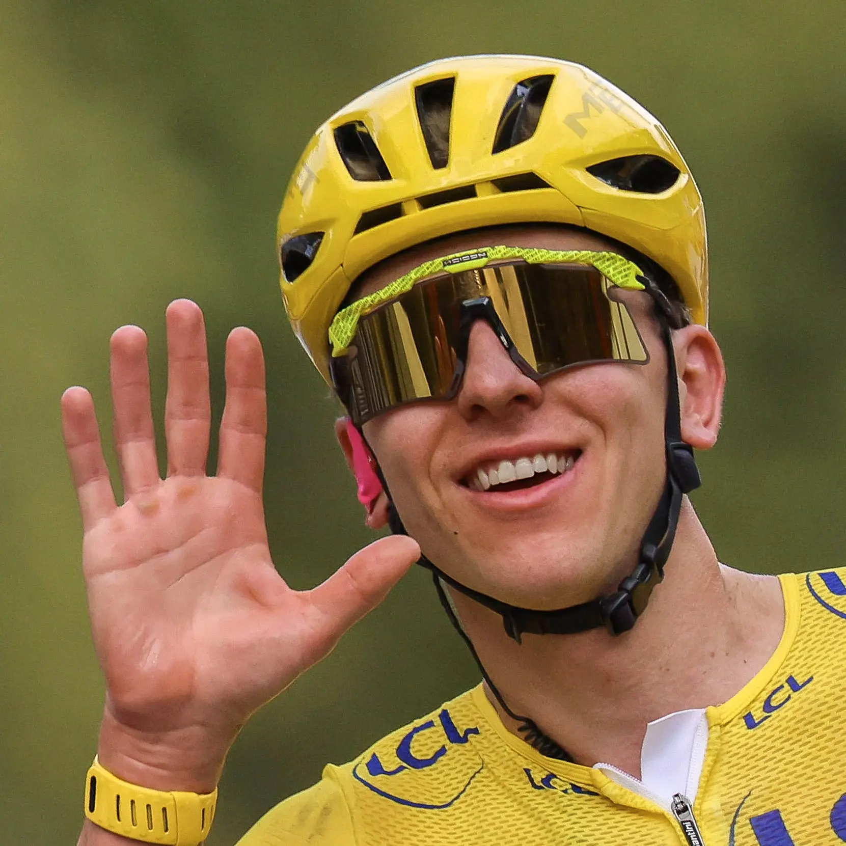 Tadej Pogačar en maillot jaune, lunettes Scicon sur le nez, lève cinq doigts