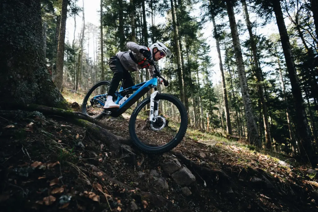 VTT électrique Cube Stereo Hybrid ONE44 franchissant des racines en forêt