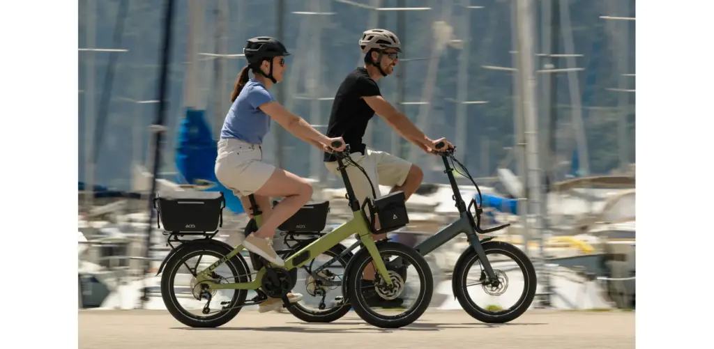 Deux cyclistes roulant sur des vélos pliants électriques Cube Fold Hybrid devant un port