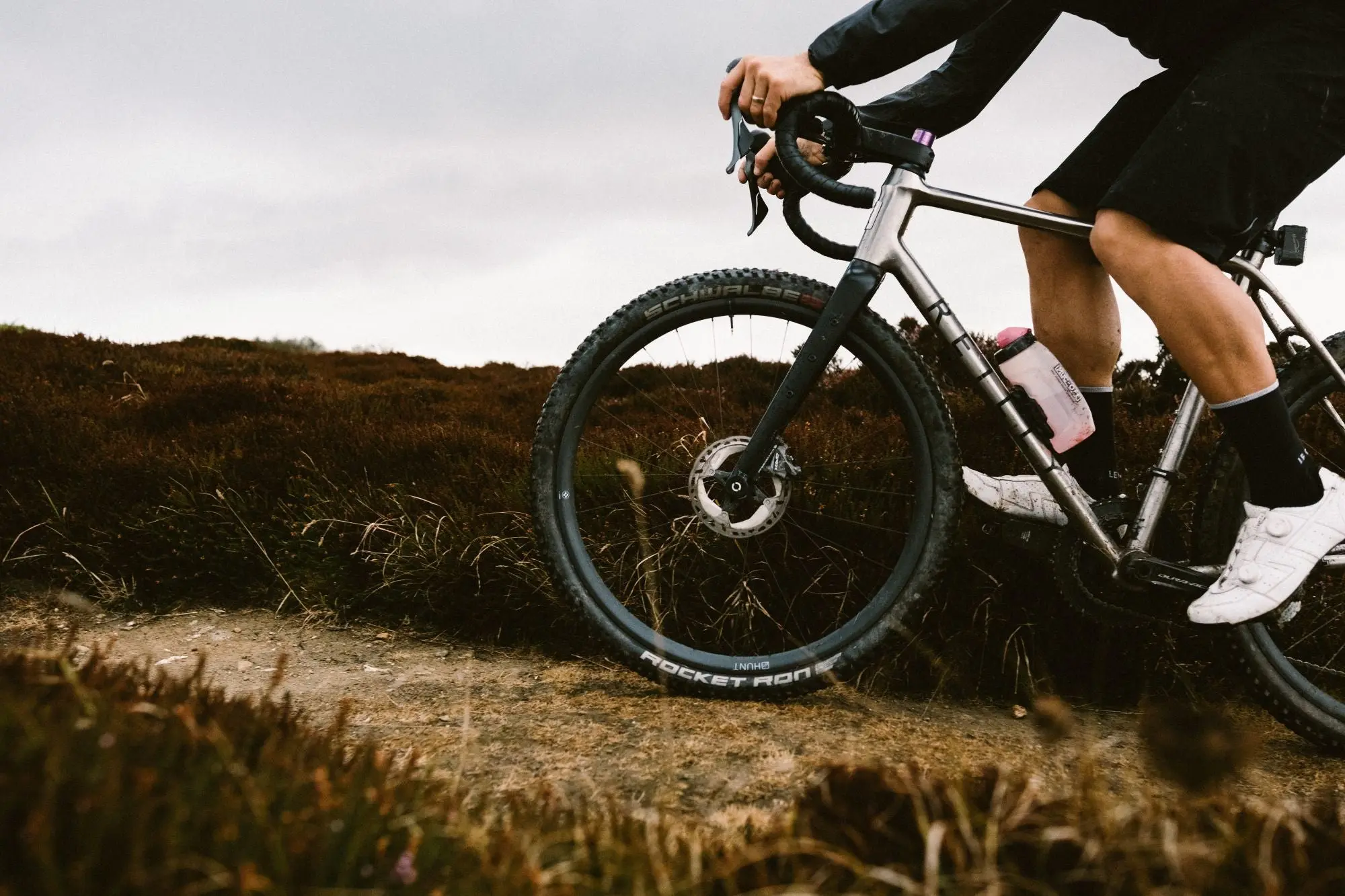 Un gravel équipé des roues Hunt 650B Adventure Carbon et de pneus larges, roulant sur un sentier de lande