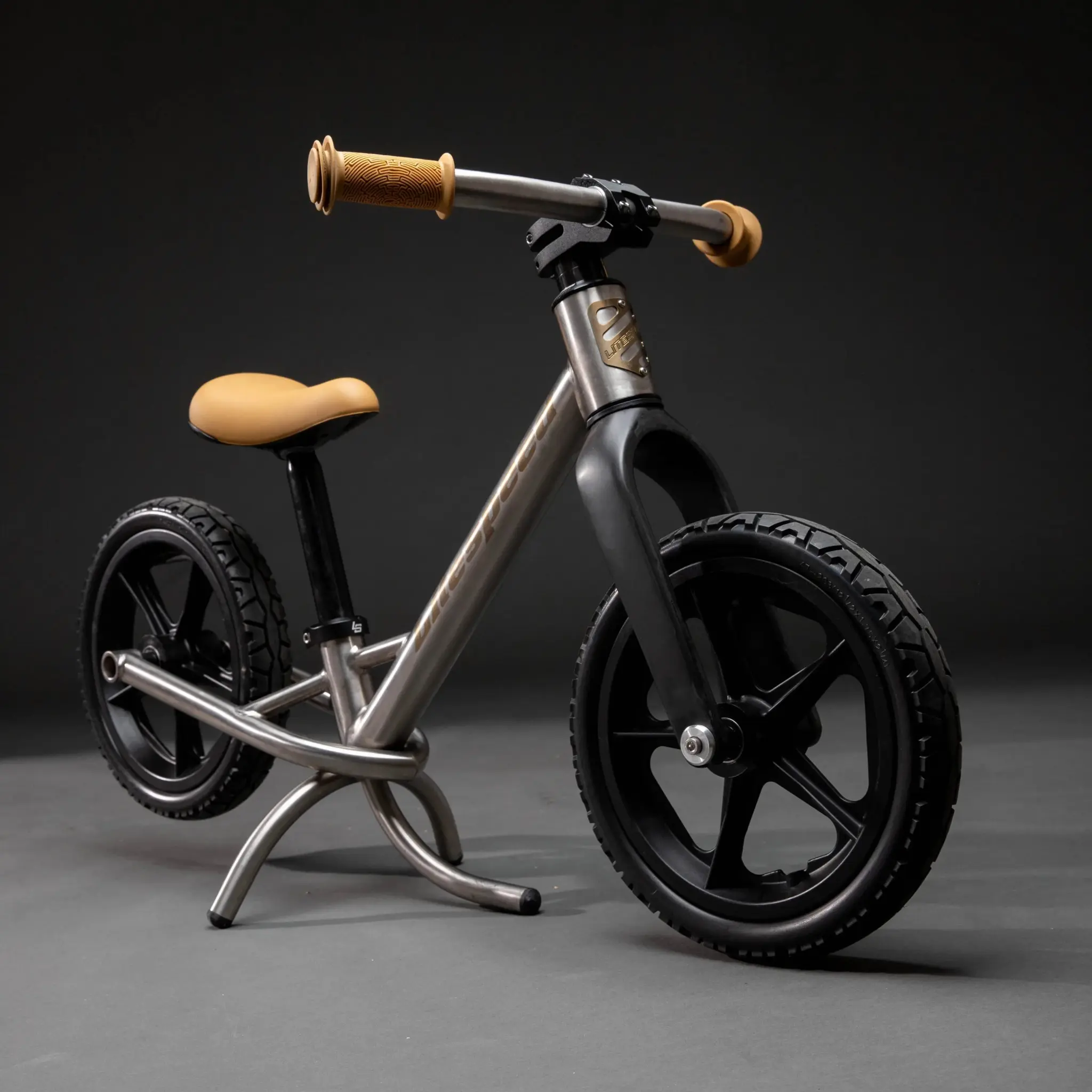 Draisienne Litespeed Rumpus vue de trois quarts, poignées et selle tan, logo doré