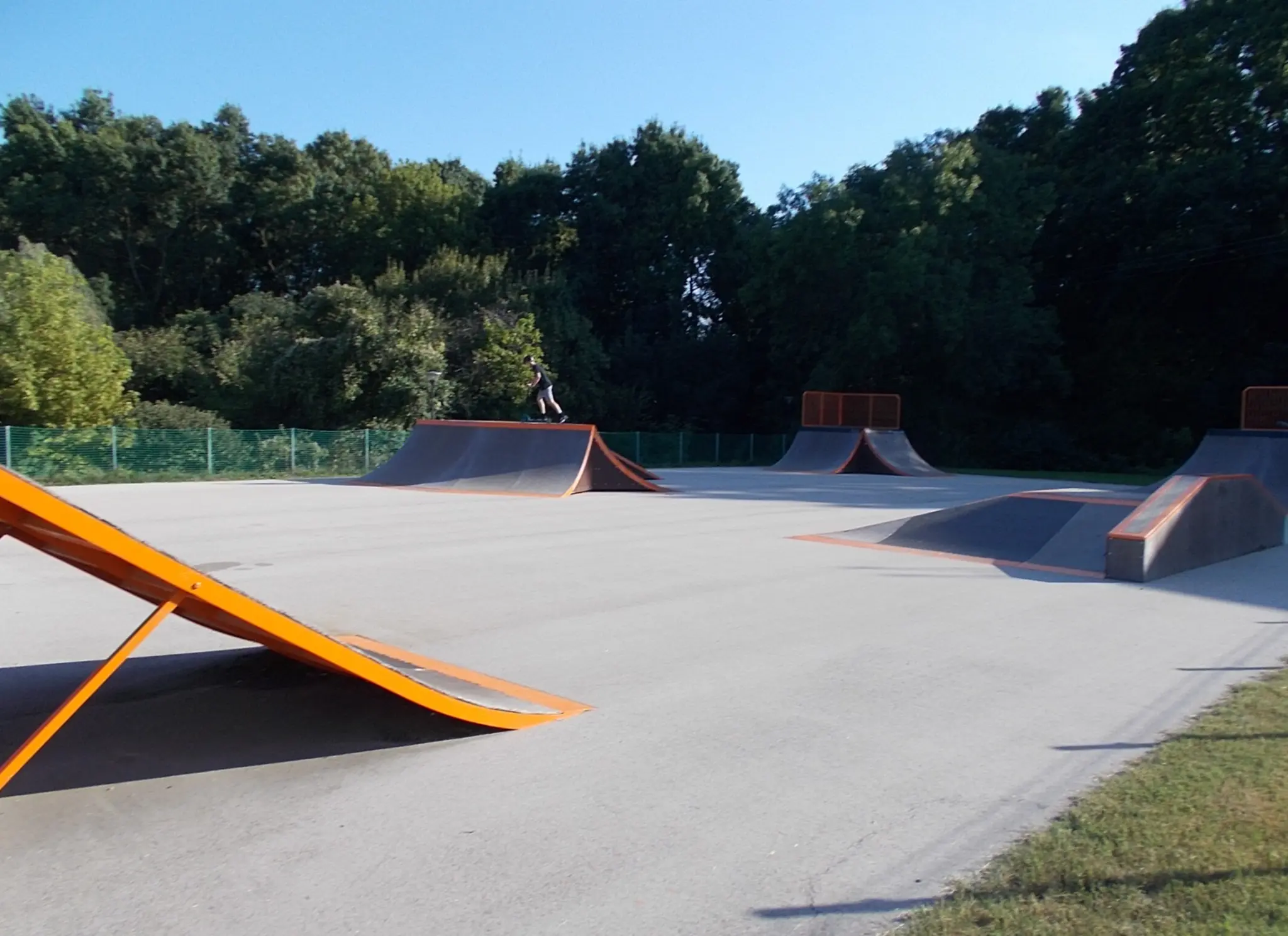 Outdoor concrete skatepark with orange ramps, almost deserted — stock photo, unrelated to Source BMX