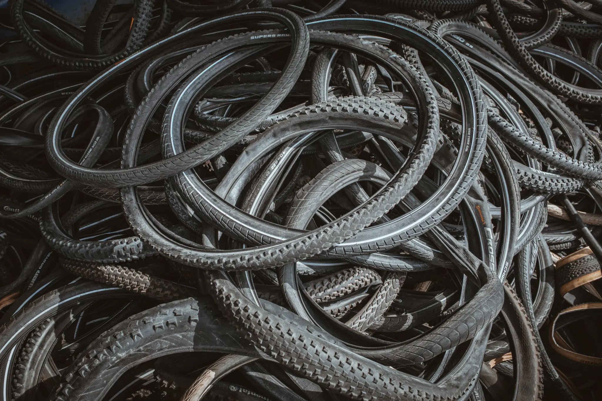 Pneus de vélo usagés empilés pour le recyclage pneus, profils route et tout-terrain mélangés