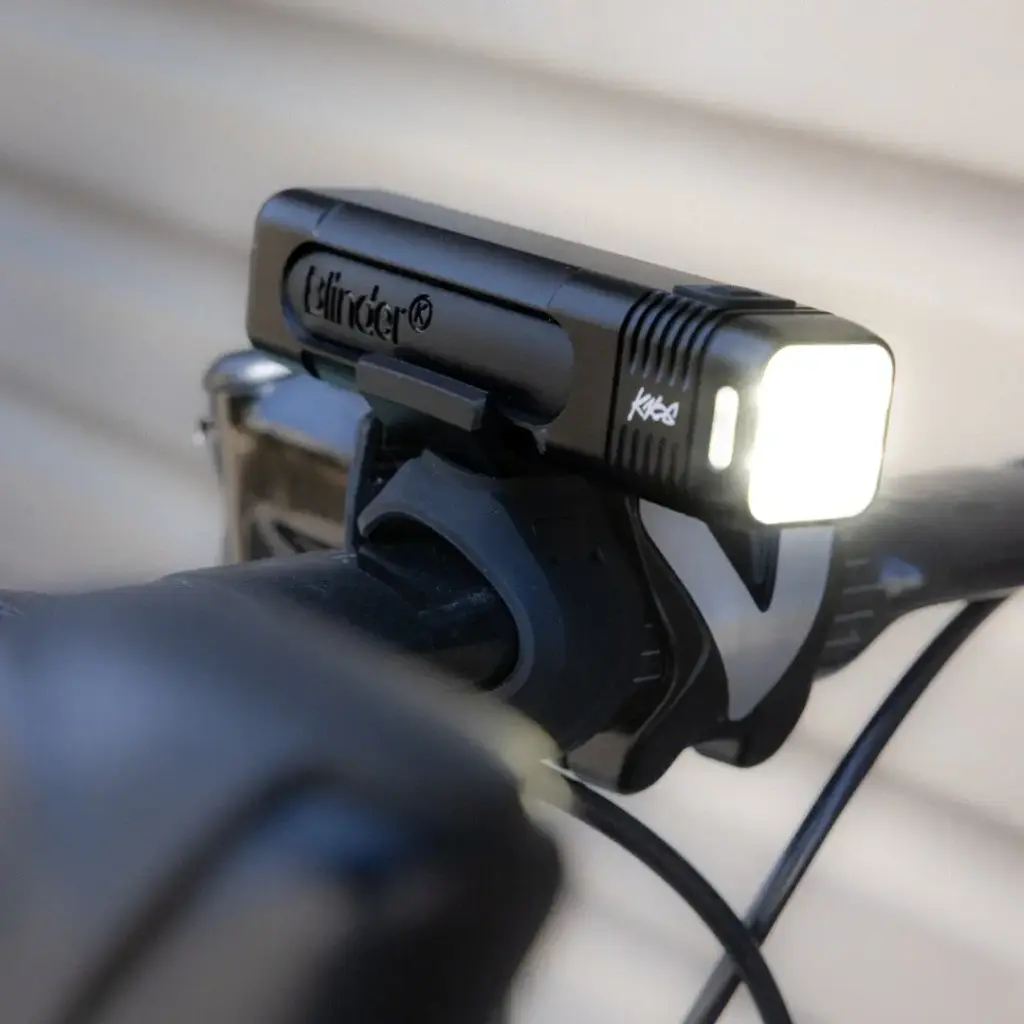 Powerful Knog Blinder 1000 bike light switched on, on a handlebar