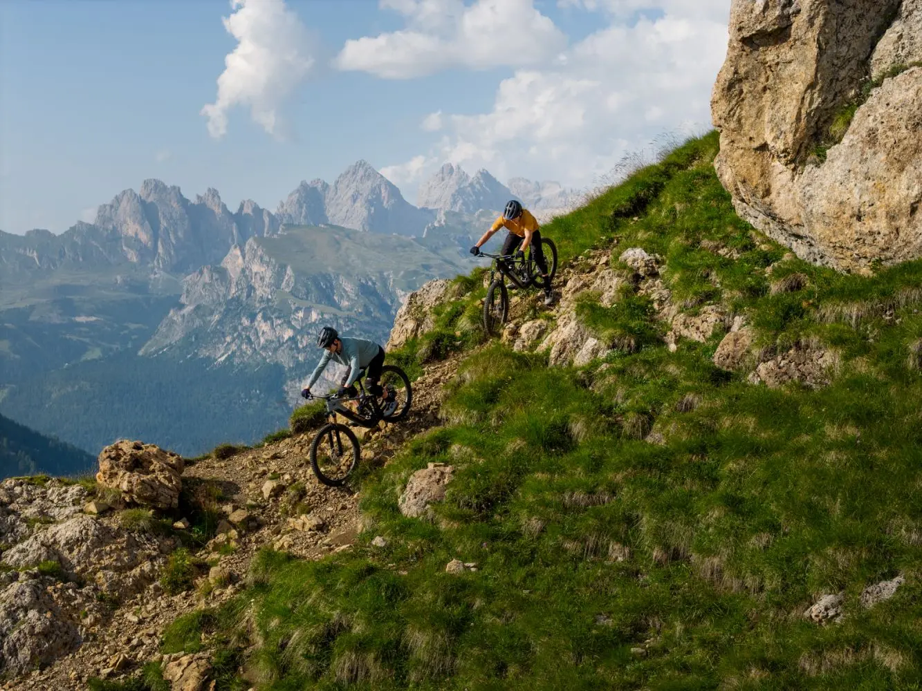 Deux vététistes descendent un sentier herbeux et rocailleux en montagne sur des Giant Trance Advanced E+