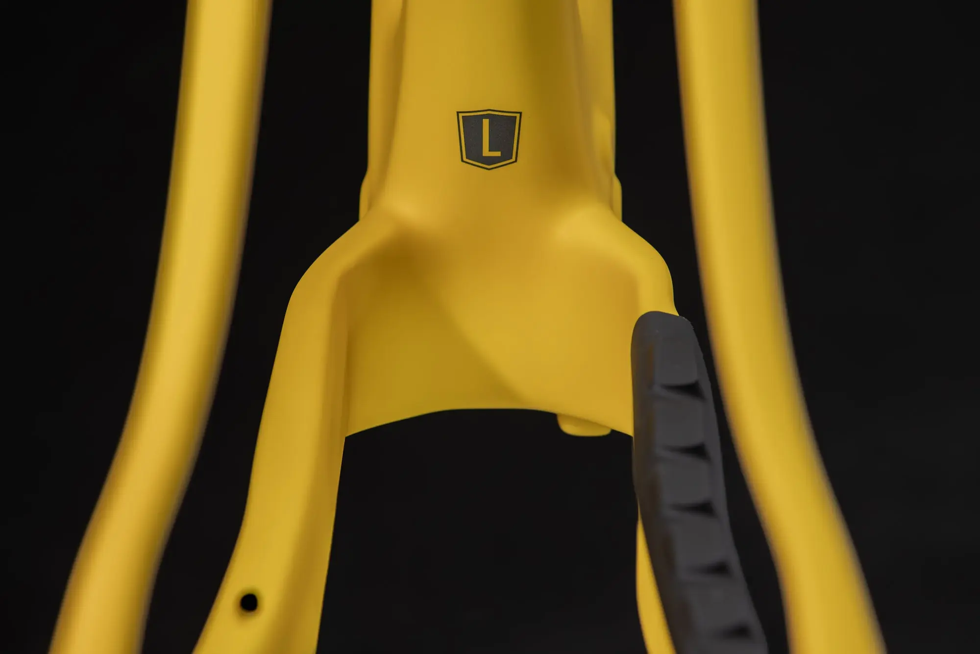 Detail of the Spot Rocker's yellow carbon frame at the rear tyre clearance