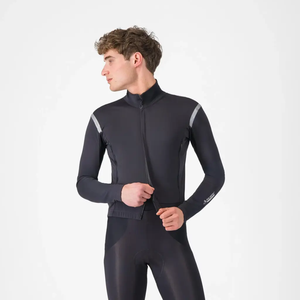 Un cycliste porte la veste vélo Castelli Perfetto RoS 3 noire, aux coutures réfléchissantes sur les épaules