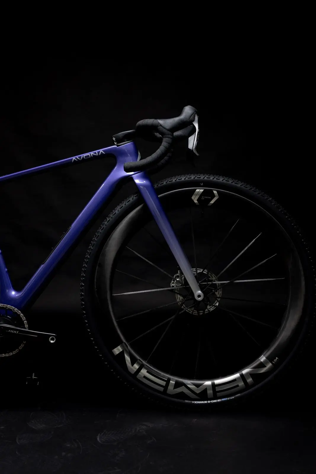 Front of a purple Avona Callis 32 on a black background, 32-inch Newmen carbon wheel and Schwalbe G-One tyre