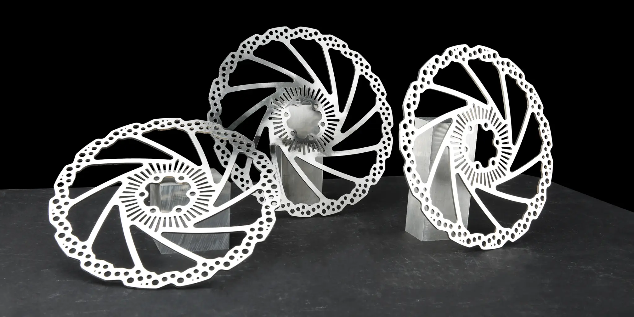 Three Hope Avinox Speed Sensor Rotors on aluminium stands, against a black background