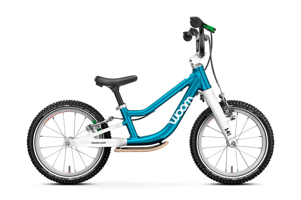 La draisienne woom GO 1 Plus bleu métallisé, vue de profil, avec son levier de frein vert