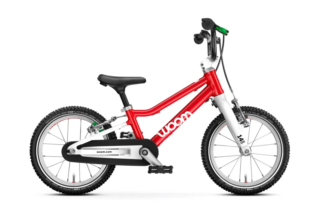 The red woom GO 2 kids' bike, side view, with its green rear brake lever